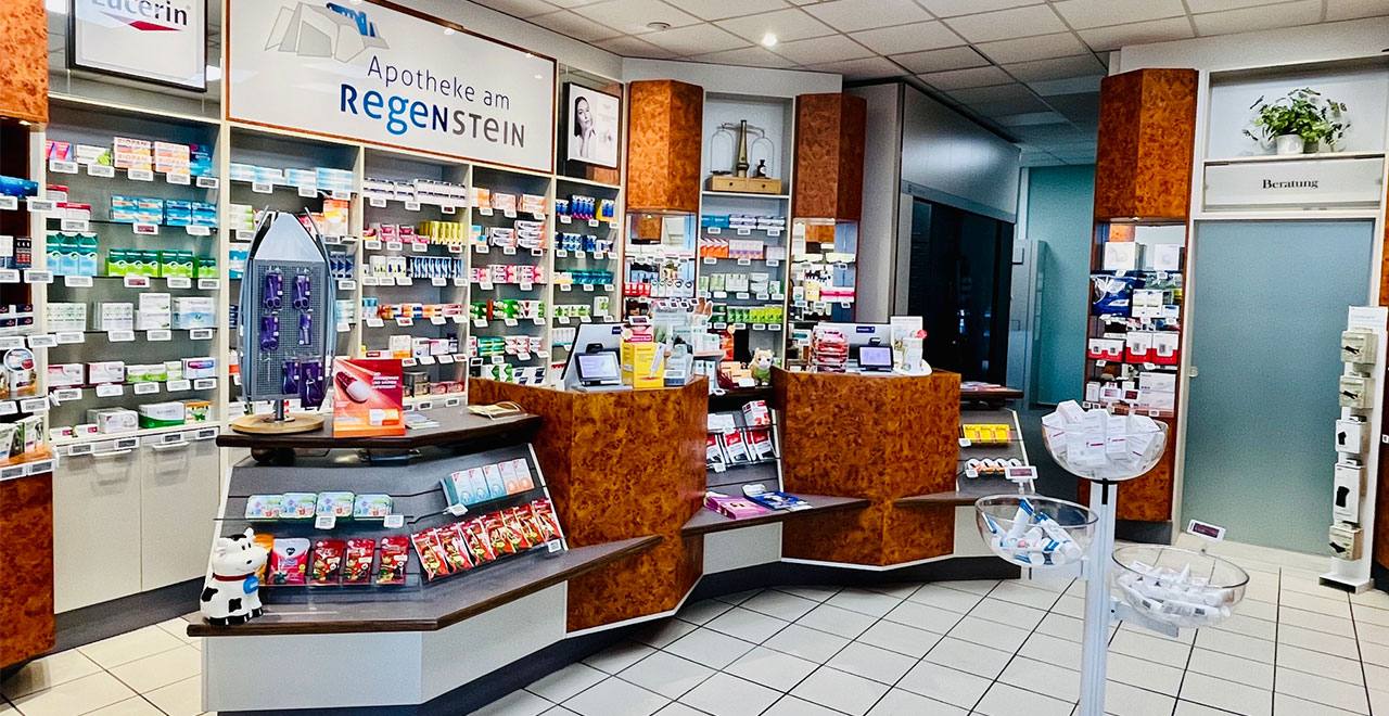 Innenansicht der Apotheke am Regenstein mit Beratungstheken und übersichtlich angeordneten Regalen für Medikamente und Gesundheitsprodukte.