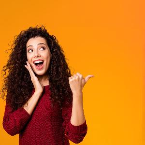Eine Frau weist lachend mit dem Daumen nach rechts zum Text.