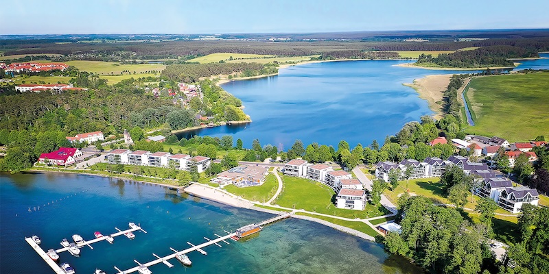 Luftaufnahme eines Sees mit Ferienanlage und Yachthafen. Text: “LINDA Gewinnspiel. Zeit für eine Auszeit am Wasser.” Logo der LINDA APotheken und “Mauremüritz Yachthafen Resort.”