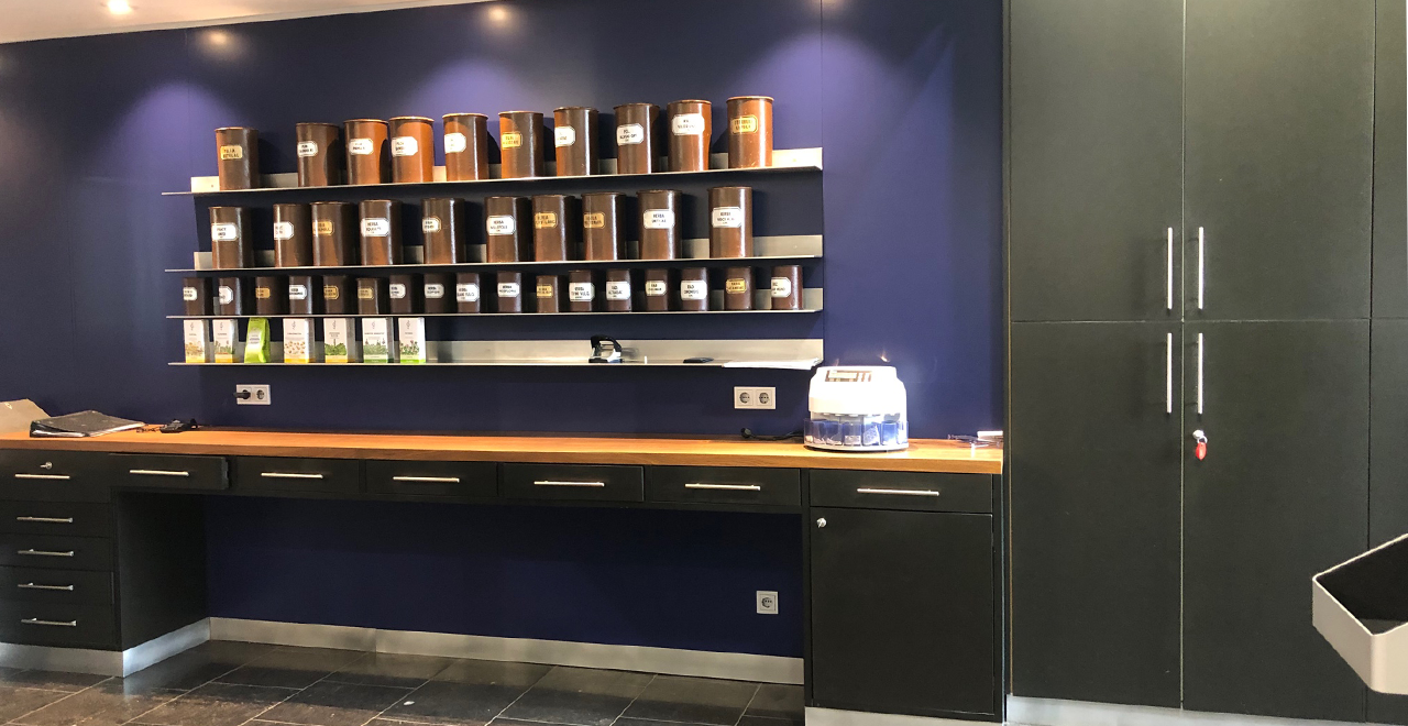 Hinterbereich einer Apotheke mit modernen Schränken, Ausgabefächern und einem automatisierten Lagersystem für Medikamente.