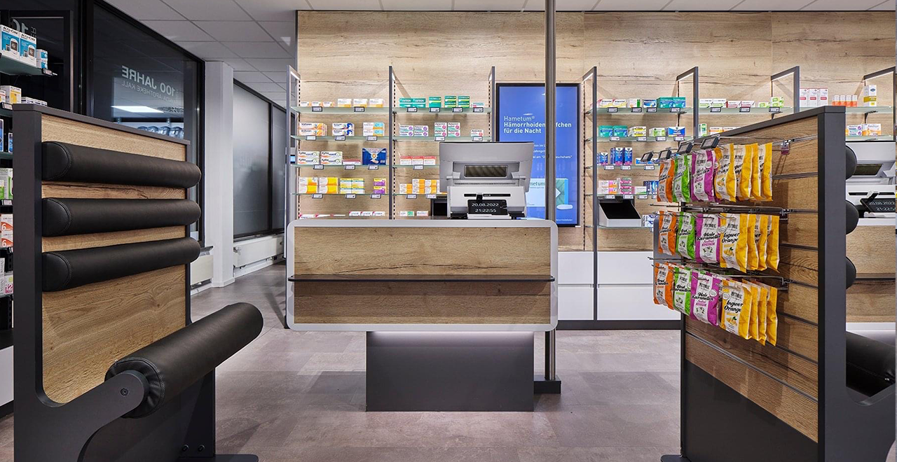 Modernes Apothekenverkaufsmodul mit Kasse, umliegenden Regalen und gesundheitsbezogenen Produkten.
