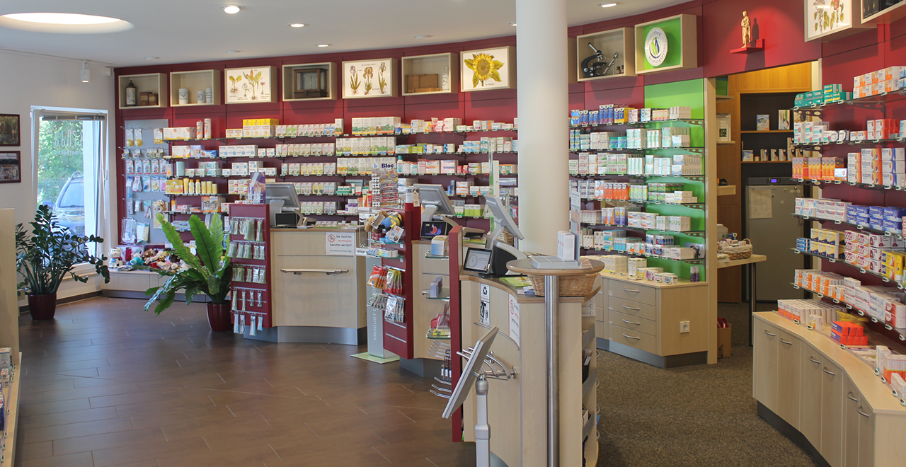 Innenraum der Fontane Apotheke mit Verkaufsregalen, Beratungstheke und Pflanzen, gut beleuchtet und übersichtlich gestaltet.