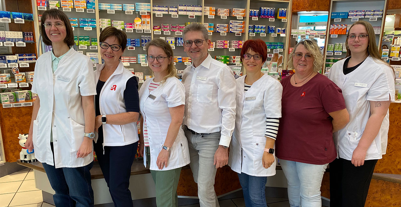 Gruppenfoto des Apothekenteams im Verkaufsraum der Apotheke.