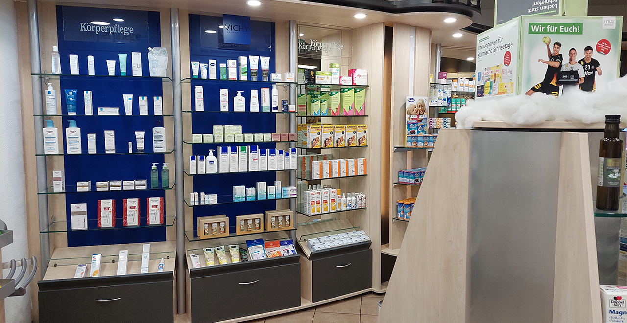 Das dritte Bild zeigt eine weitere Sektion der Apotheke, die sich auf Körperpflegeprodukte konzentriert. Regale sind mit Hautpflegeprodukten und anderen Körperpflegeartikeln gut bestückt. Bekannte Marken sind sichtbar, und es gibt eine Präsentation von Produkten zur Unterstützung des Wohlbefindens.