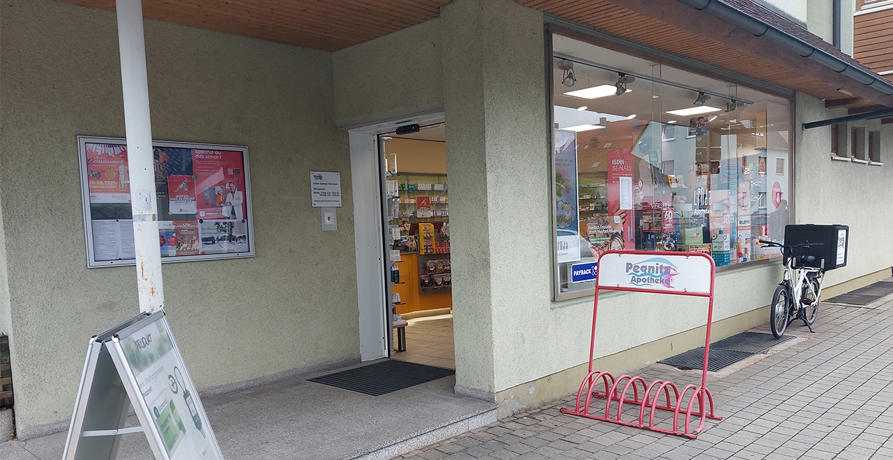 Barrierefreier Eingang der Pegnitz Apotheke mit Fahrradständer und großer Fensterfront.